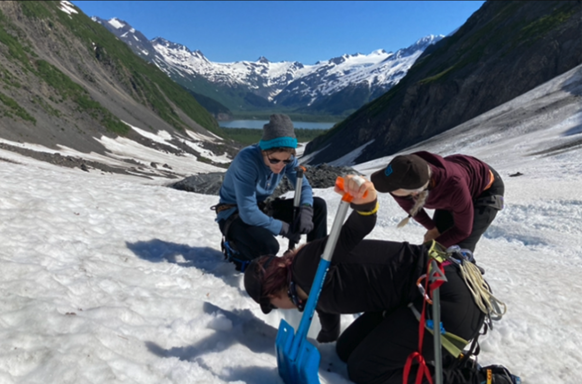 Photo of Shaun, Summer, and Dr. Lyons shoveling snow in the mountains